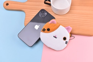 Detail of cute plush cat coin purse with embroidered face and metal ball chain