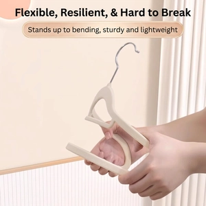 Off-white non-slip velvet clothes hanger with silver hook showing flexible durable material