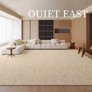Modern minimalist beige boucle area rug in a luxury living room setting with a white sofa