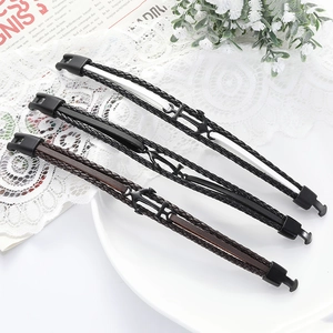 Three men's retro braided leather bracelets with black metal anchor clasps on a tray