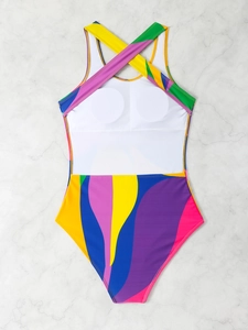 Detailed flat lay of a colorful one-piece swimsuit with abstract wave print and cross back straps
