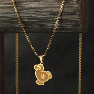 Golden stainless steel dodo bird pendant necklace for women on dark wooden display stand