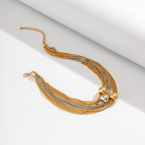 Detail of multi-layered punk necklace featuring gold and silver spherical beads