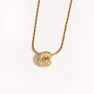 Détail du collier en chaîne dorée tressée avec pendentif lettre C pavé de zircons fins