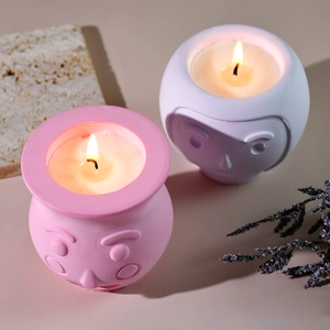 Dettaglio di vasetti per candele con rilievo viso cartoon in rosa e viola opaco