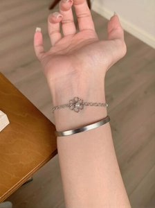 Vue détaillée du bracelet fleur perle argenté et du jonc ouvert au fini mat