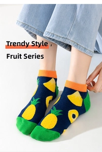 Close-up of cotton fruit socks featuring pineapple and lemon patterns on blue fabric