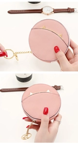 Detail of pink round coin purse with golden cat ears and convenient keychain hook