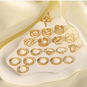 Close-up of 18k gold plated snake and star rings set on an elegant stone tray