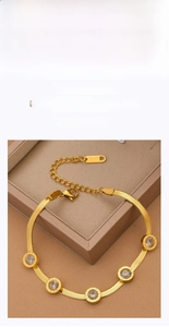 Close-up of golden snake chain bracelet with four crystal pendants and adjustable clasp