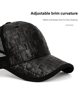 Detail of black straw baseball cap showing woven texture and wide curved brim for sun protection