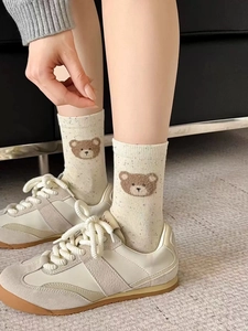 Close-up of knit cotton crew sock with cute brown bear embroidery and colorful specks