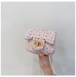 Close-up of pink tweed fabric texture and gold metal turn-lock on the chain bag