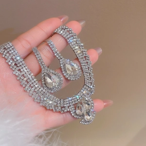 Detail of silver teardrop necklace and earrings set featuring micro-pave crystal rhinestones