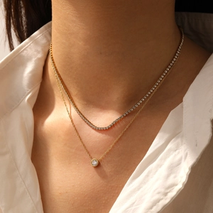 Close-up of double-layer gold necklace featuring a diamond pendant and a sparkling choker