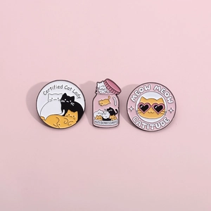 Detailed set of cute enamel cat pins featuring white black and orange motifs on pink background