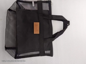 Vista dettagliata della borsa a rete nera con etichetta in pelle e cerniera lampo
