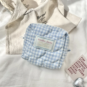 Dettaglio della borsa cosmetica trapuntata a quadretti blu e bianchi con cuori