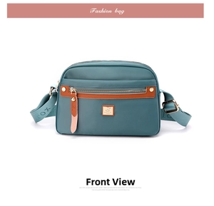 Detail of blue nylon crossbody bag with multi-zipper layers and woven FOX shoulder strap