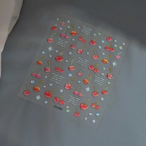 Detailed close-up of 3D cherry nail stickers with silver stars and glitter accents