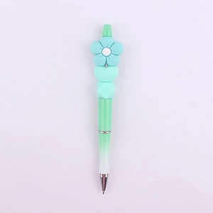 Detailed macro view of DIY beaded pen featuring blue silicone flower and heart-shaped beads