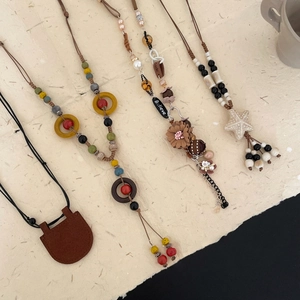 Detail view of retro bohemian necklaces with leather charms and ethnic wood beads