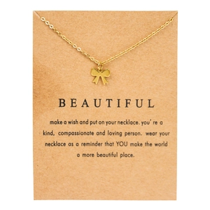 Golden bow pendant necklace on a decorative Kraft paper gift card with sweet message