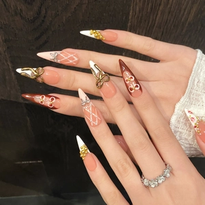 Handmade stiletto press-on nails with deep red tortoise pattern and gold bow charm