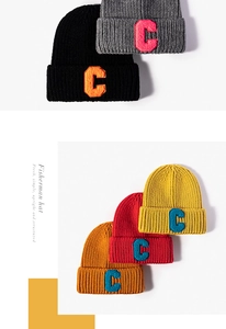 Detailed view of knitted beanies with various colors and towel-embroidered C-letter patches