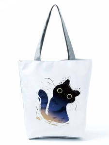 Detail of white canvas tote bag featuring starry black cat print and grey fabric handles