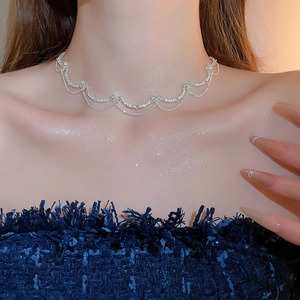 Close-up of sparkling zircon butterfly heart choker necklace with wavy tassel design