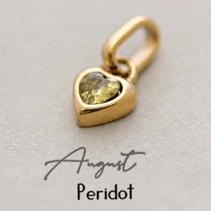 Macro detail of gold heart pendant with August peridot birthstone for DIY necklaces