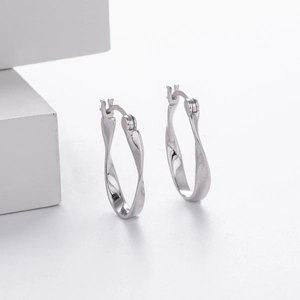 Detail shot of silver Mobius twisted hoop earrings with a polished metallic finish