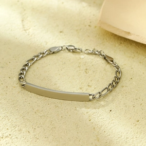 Detailed view of silver stainless steel curb chain with smooth curved metal bar plate