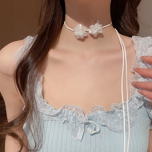 Gros plan d'un collier ras du cou fleur blanche vintage français avec lien fin sur mannequin