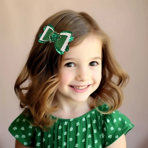 Smiling girl wearing green glitter St. Patrick's Day bow hair clip with clover design