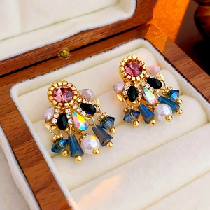 Macro detail of vintage tassel earrings with pink stones, blue crystals and pearls