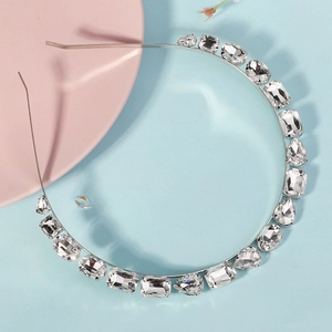 Close-up of a silver headband with sparkling clear rhinestones in various geometric shapes