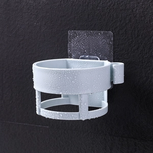 Wall-mounted light blue hair dryer holder with water droplets on a bathroom wall