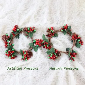 Detail van kerstkaarsringen met rode bessen, dennenappels en groene bladeren decor