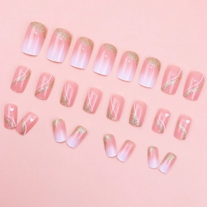 Pink and white gradient press-on nails with gold glitter French tips and heart patterns