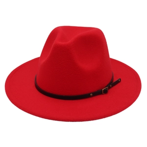 Detail of red fedora hat featuring black leather band with golden studs and buckle