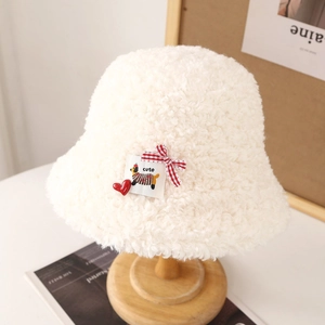 Détail macro du bob en laine d'agneau blanche avec écusson chiot mignon et breloque coeur