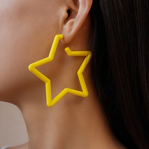 Gros plan d'une boucle d'oreille étoile jaune en acrylique portée par un mannequin