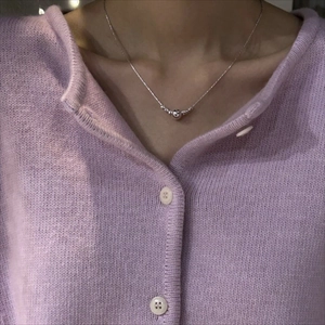 Minimalist 925 sterling silver beaded necklace shown on model wearing lilac cardigan