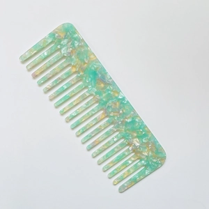 Detailed view of pale green marble-textured acetate hair comb with wide teeth design