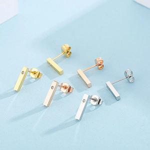 Three pairs of minimalist bar stud earrings in gold, silver, and rose gold with tiny diamonds