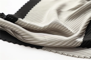 Close-up of pleated silk scarf texture featuring elegant black and silver color-blocking