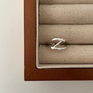 Minimalist 925 sterling silver ring with abstract geometric Z-shaped design on jewelry box