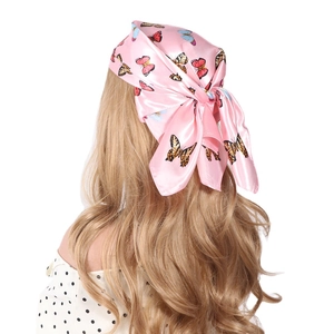 Pink silk square scarf with colorful butterfly patterns worn as a Bohemian headband